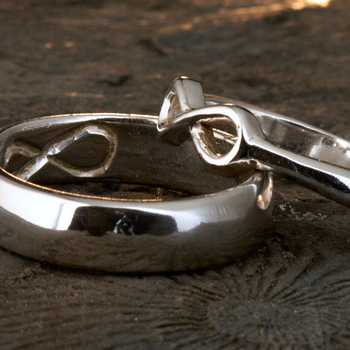 Handgefertigter Statement-Partnerring aus poliertem 925 Silber von Silberschweif mit großer Unendlichkeitsschleife (6x14mm). Die Schiene verjüngt sich elegant zum Motiv. Massiver 6mm Herrenring aus Silber. In der Innenansicht zeigt sich das fest eingravierte Unendlichkeits-Symbol als geheimes Zeichen der Verbundenheit.  Das Partnerring-Set „Ewigkeit“ zeigt das plastische Design des Damenrings und die spiegelnde Oberfläche des massiven Herrenrings