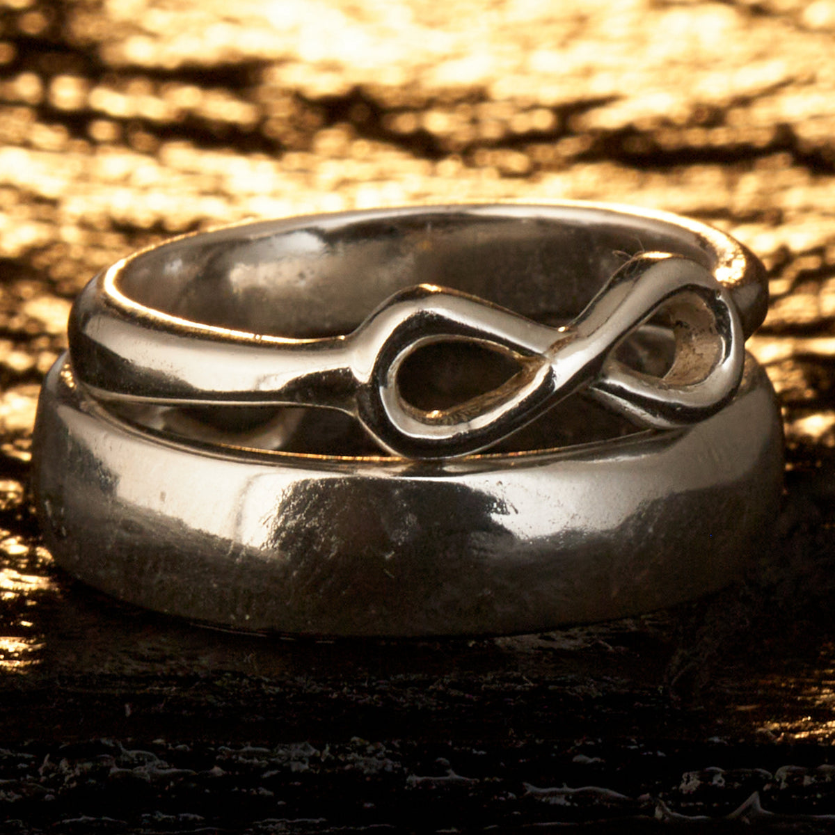  Handgefertigter Statement-Partnerring aus poliertem 925 Silber von Silberschweif mit großer Unendlichkeitsschleife (6x14mm). Die Schiene verjüngt sich elegant zum Motiv. Massiver 6mm Herrenring aus Silber. In der Innenansicht zeigt sich das fest eingravierte Unendlichkeits-Symbol als geheimes Zeichen der Verbundenheit.  Das Partnerring-Set „Ewigkeit“ zeigt das plastische Design des Damenrings und die spiegelnde Oberfläche des massiven Herrenrings