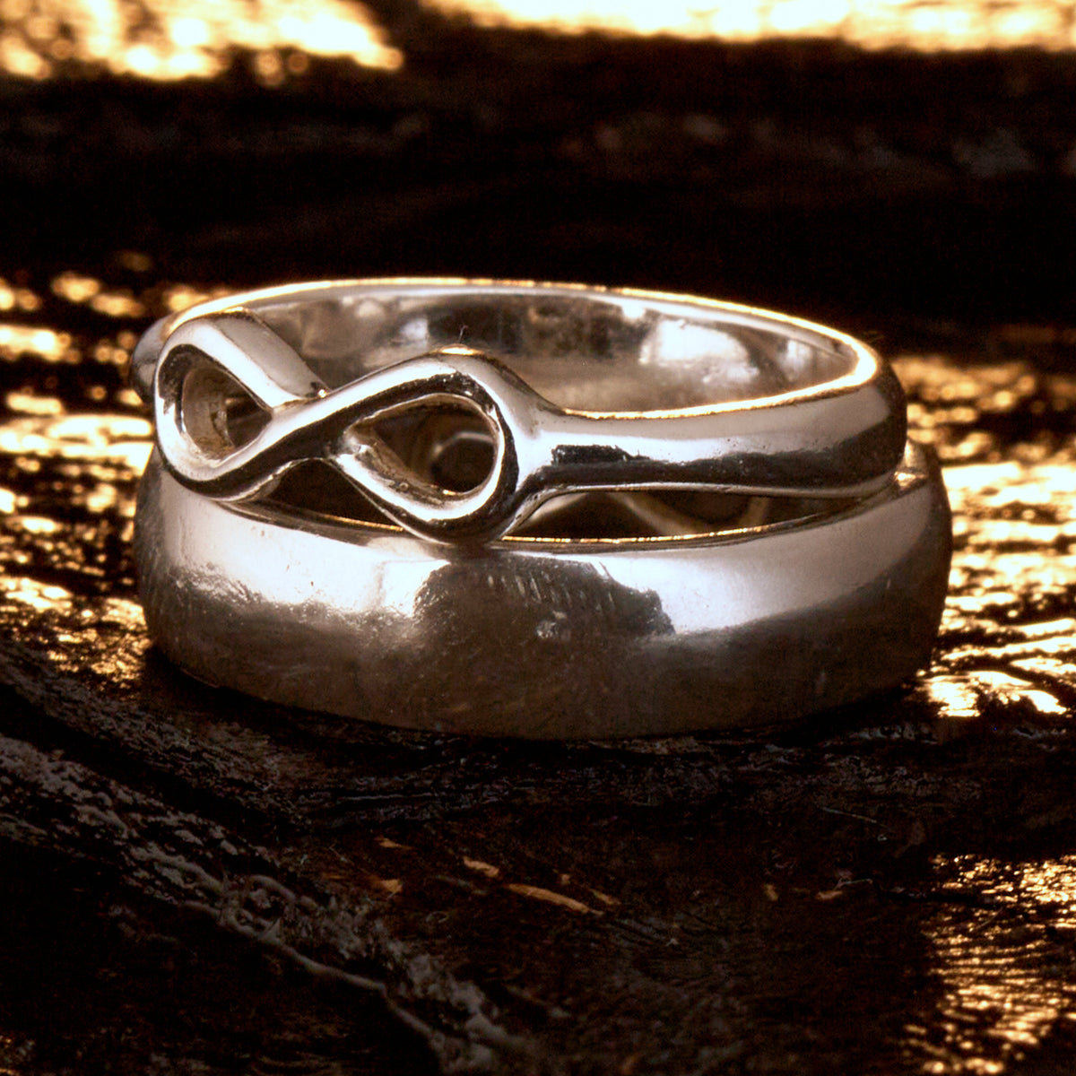  Handgefertigter Statement-Partnerring aus poliertem 925 Silber von Silberschweif mit großer Unendlichkeitsschleife (6x14mm). Die Schiene verjüngt sich elegant zum Motiv. Massiver 6mm Herrenring aus Silber. In der Innenansicht zeigt sich das fest eingravierte Unendlichkeits-Symbol als geheimes Zeichen der Verbundenheit.  Das Partnerring-Set „Ewigkeit“ zeigt das plastische Design des Damenrings und die spiegelnde Oberfläche des massiven Herrenrings